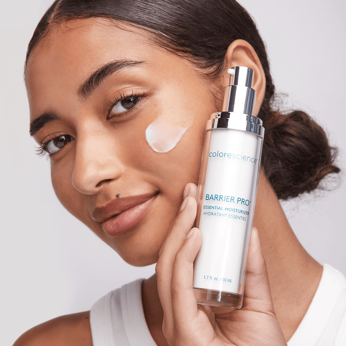 Frau trägt Colorescience Barrier Pro Essential Moisturizer Gesichtscreme auf