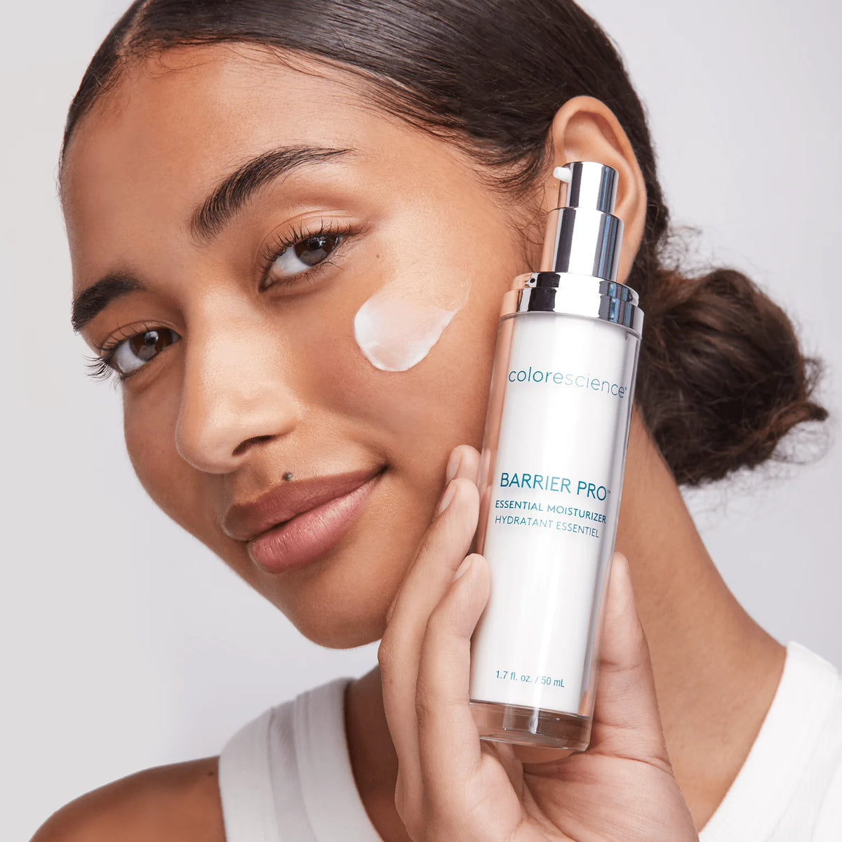 Frau trägt Colorescience Barrier Pro Essential Moisturizer Gesichtscreme auf